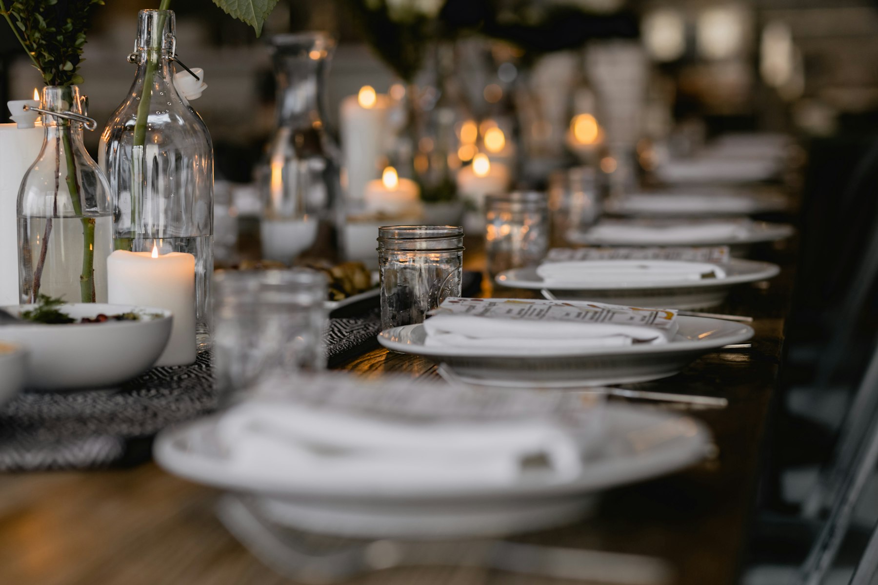 Catering Long candlelit dinner table set for an event