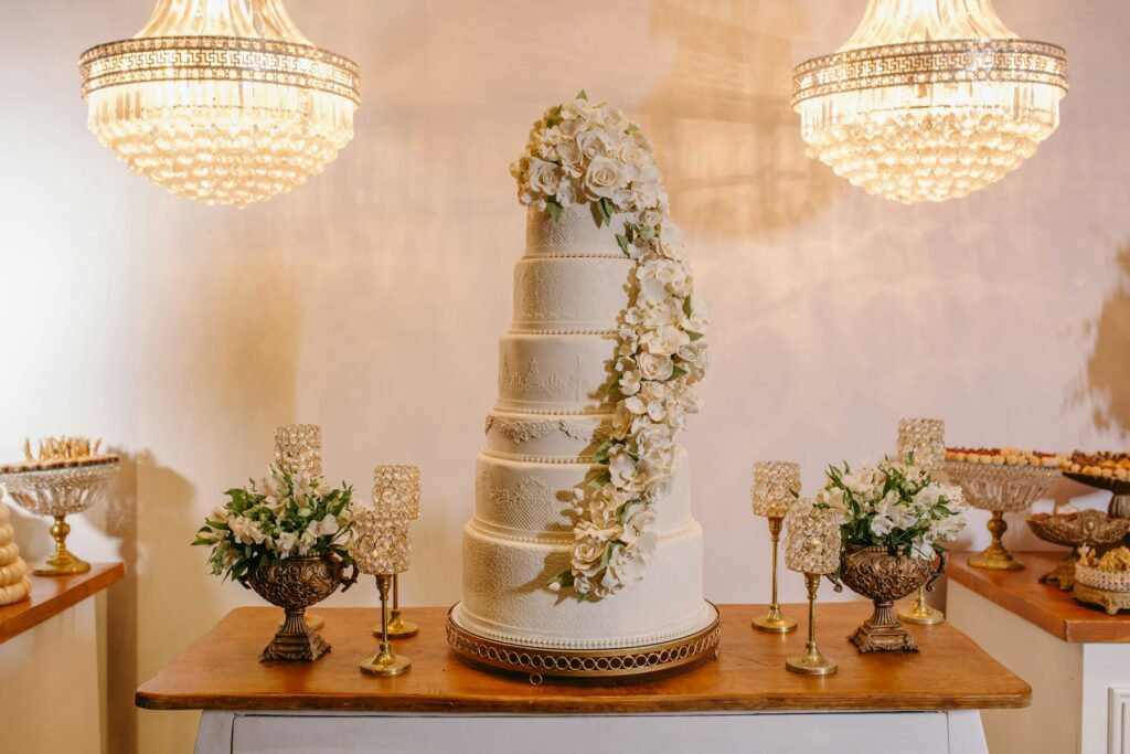 Tiered white wedding cake decorated with flowers on a reception table